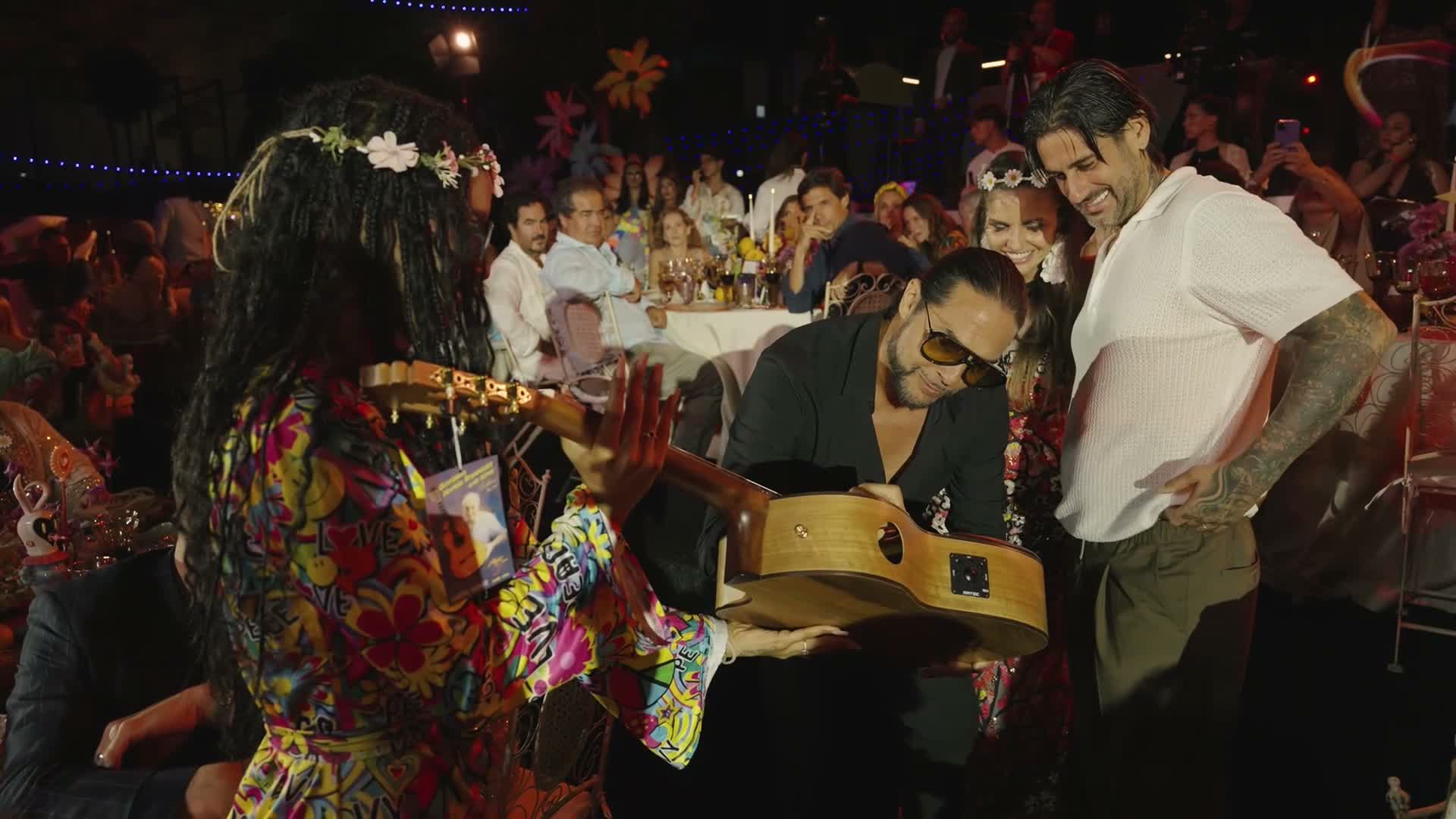El momento de la firma de la guitarra, sobre la mesa, durante la gala